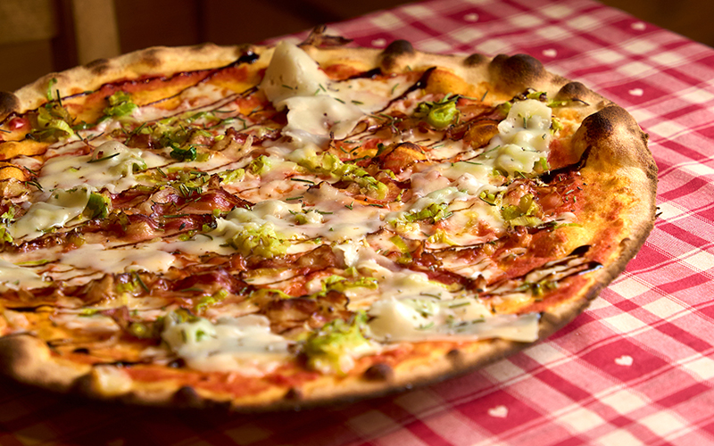 pizza Fratta con pancetta trentina da allevamento estensivo (in cottura), Asiago DOP fresco, porri, glassa di aceto balsamico, rosmarino